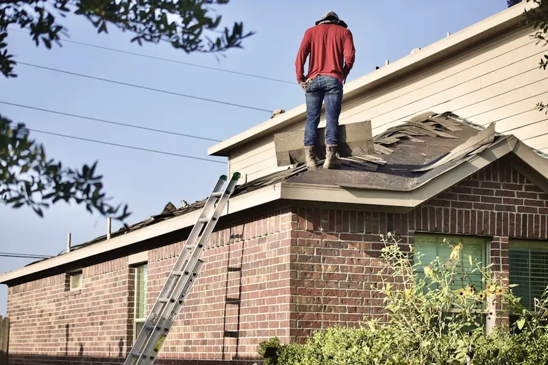 Professional roofer working on a residential roof in Northeast K-96